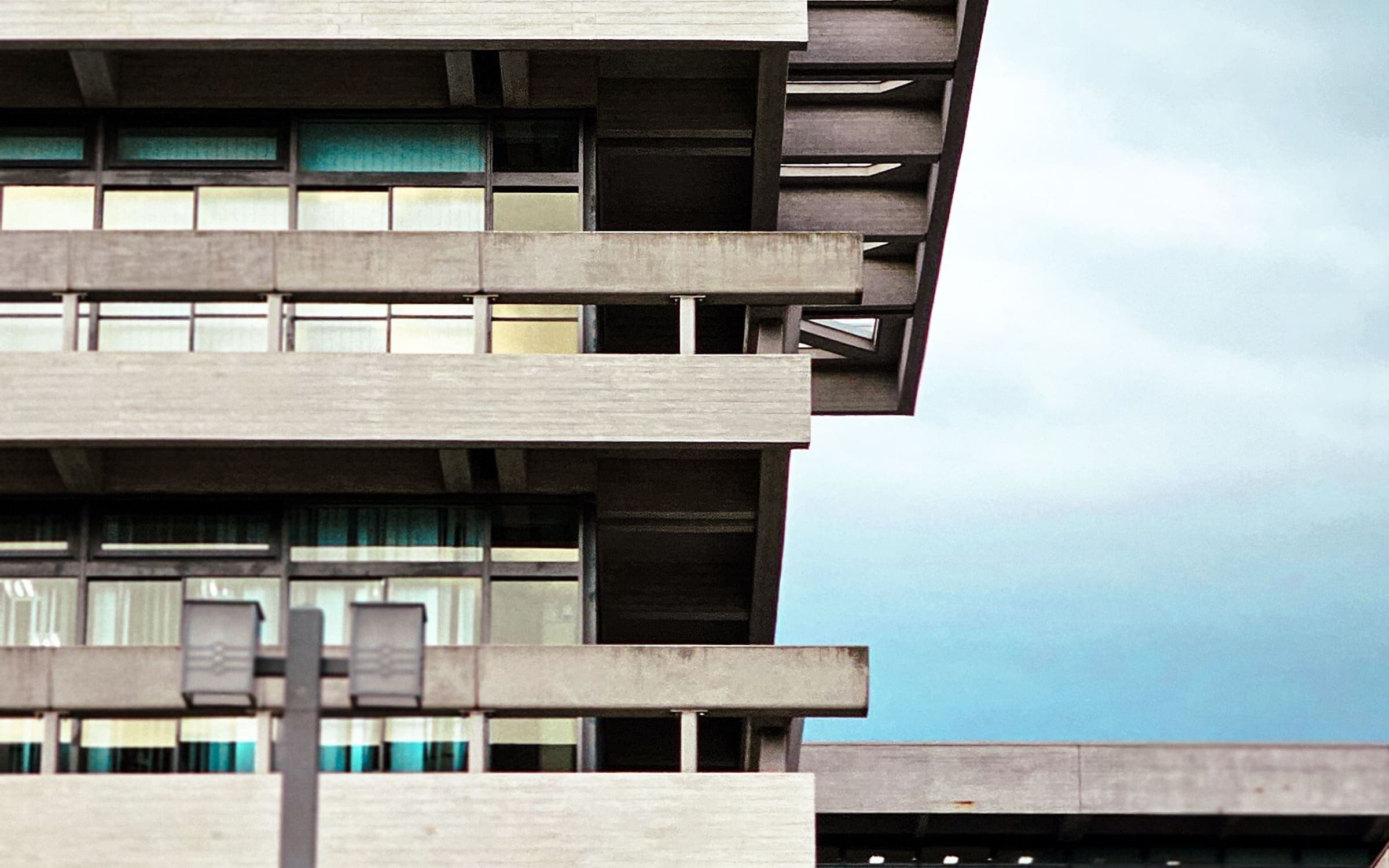 Edificio de departamentos con balcones corridos y parasoles de hormigón