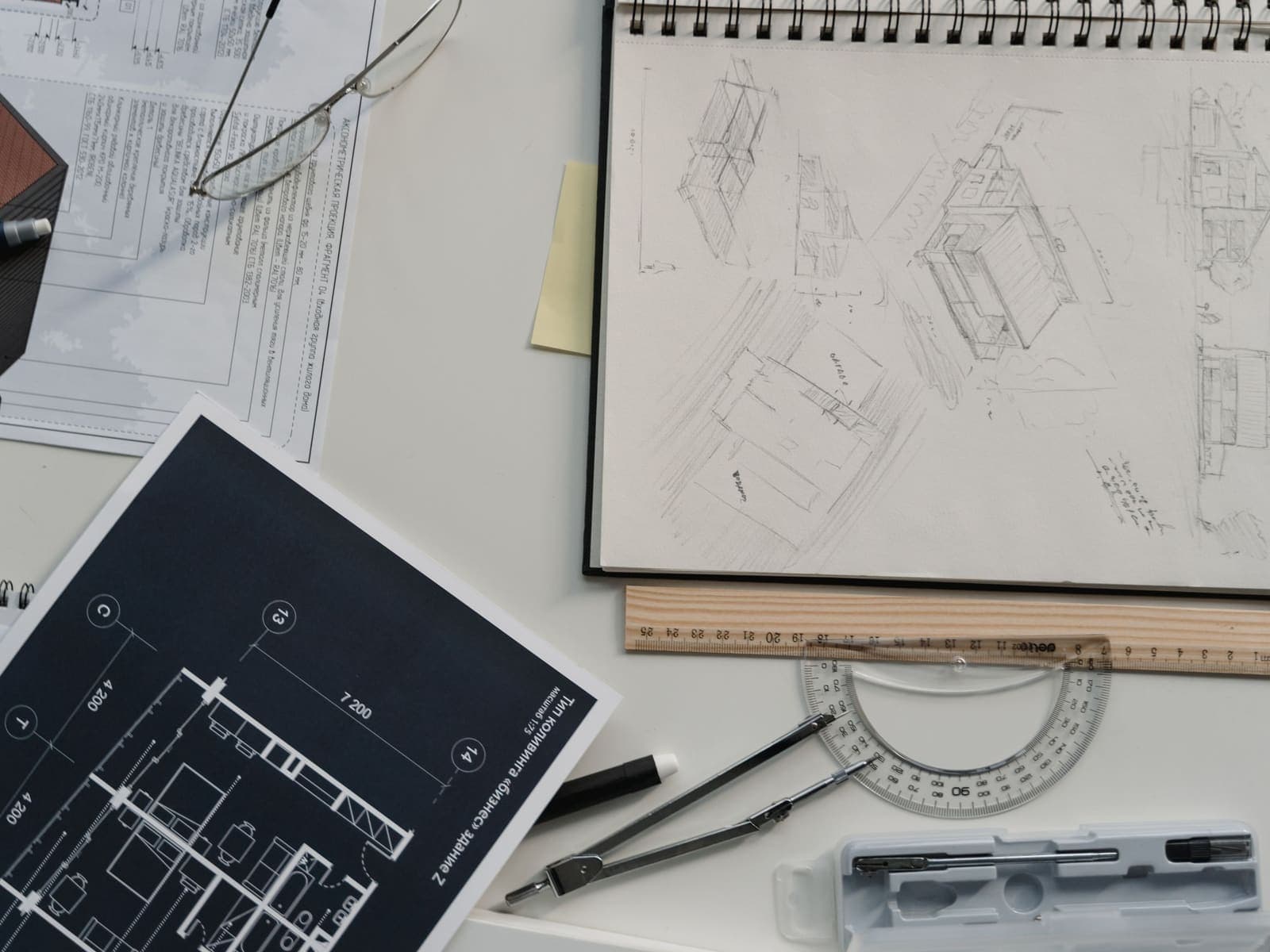 Tablero con planos, bocetos y herramientas de dibujo sobre la mesa del estudio