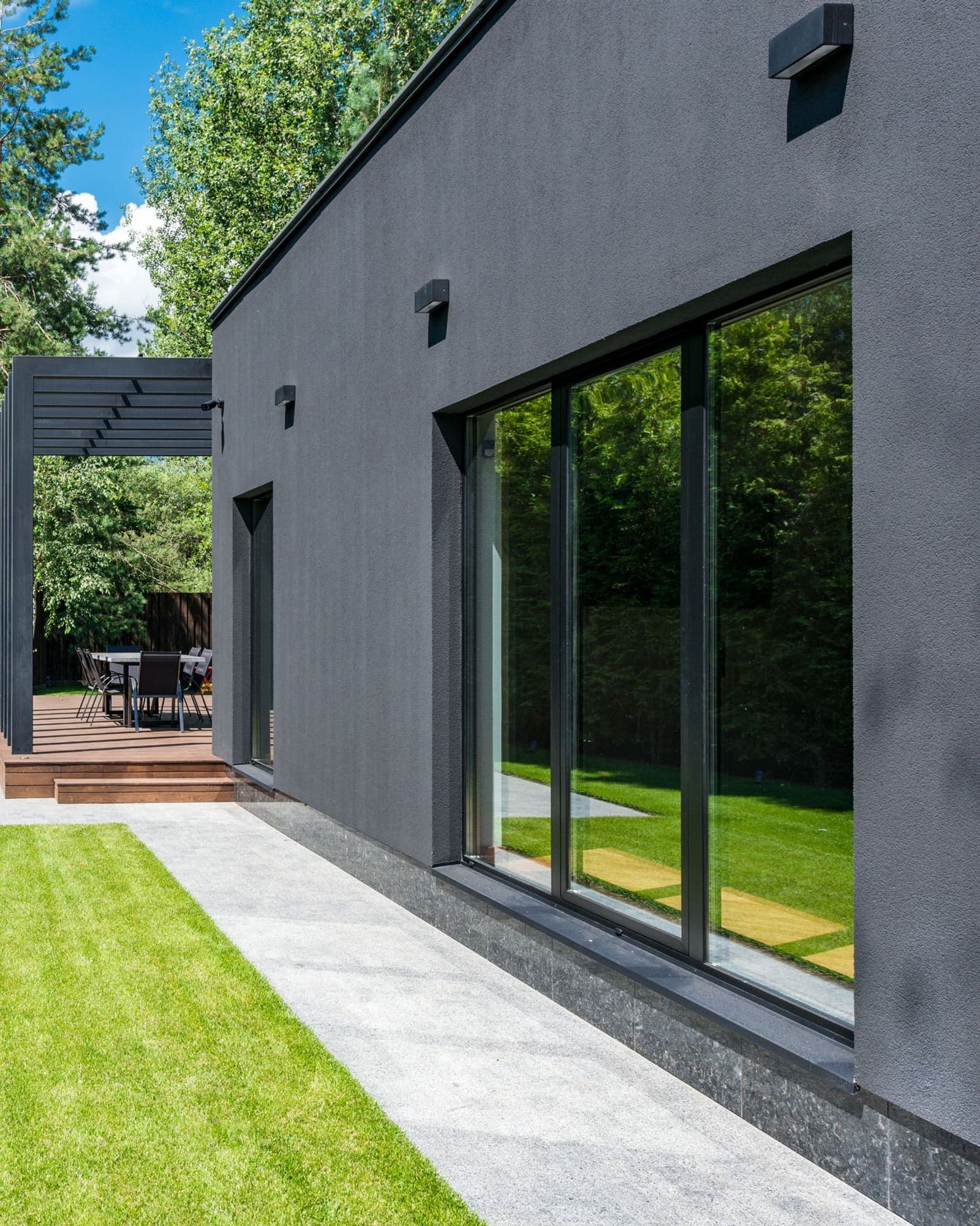 Frente vidriado de una vivienda entregada, con la galería y el parque al costado